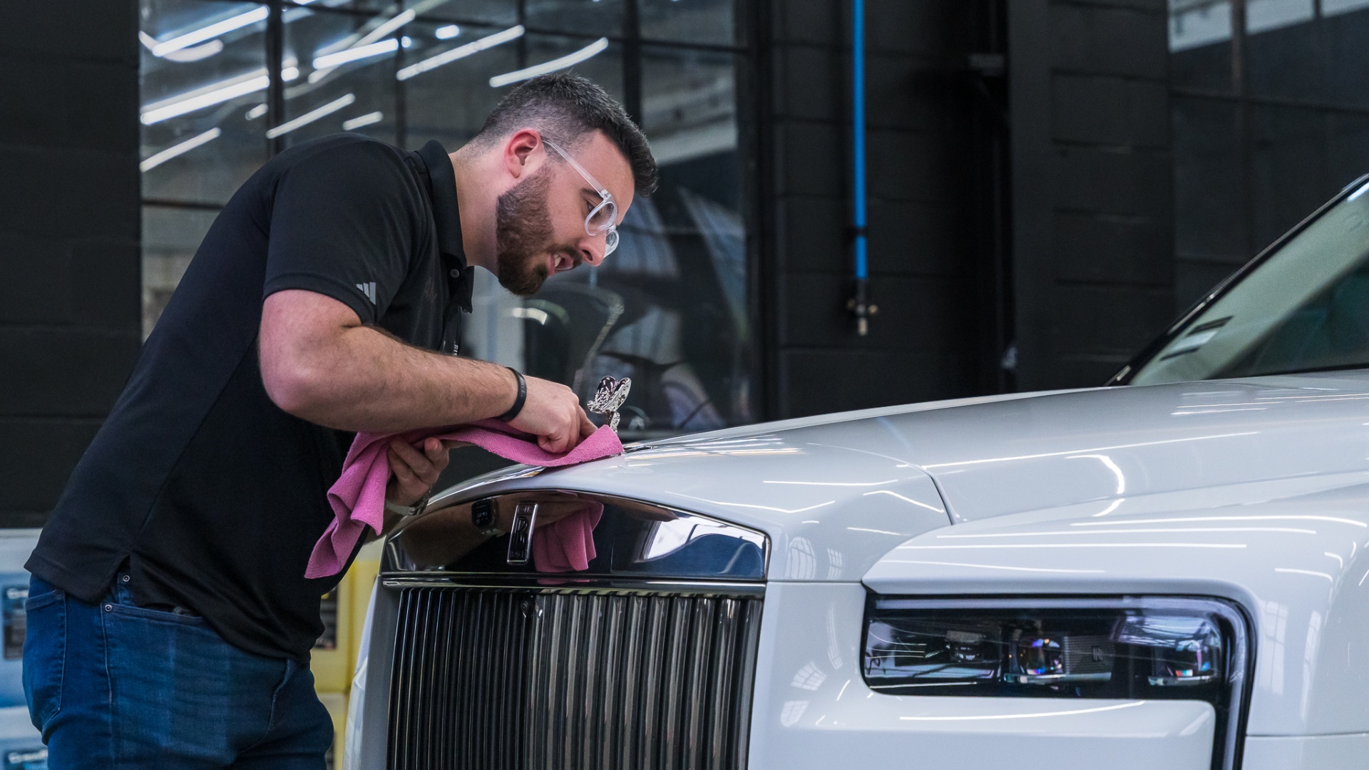 Technician hand-detailing a Rolls-Royce hood