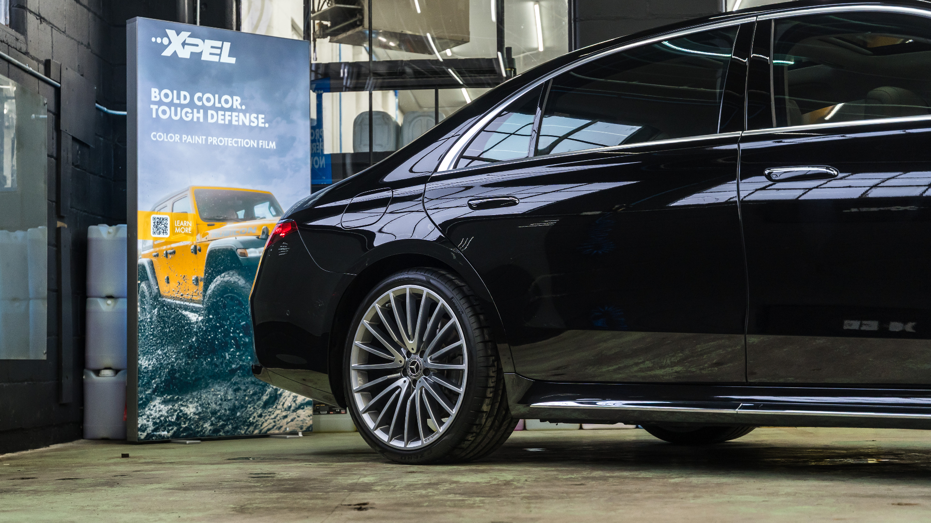 Black Mercedes S550 4Matic beside XPEL banner